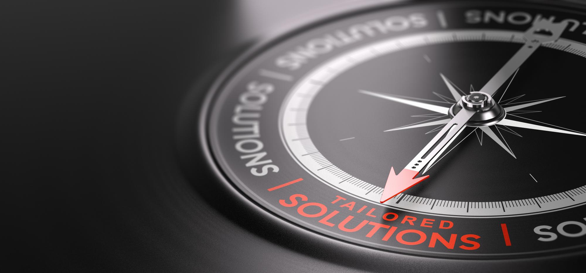 Photo of a compass pointing to text that reads, "tailored solutions"